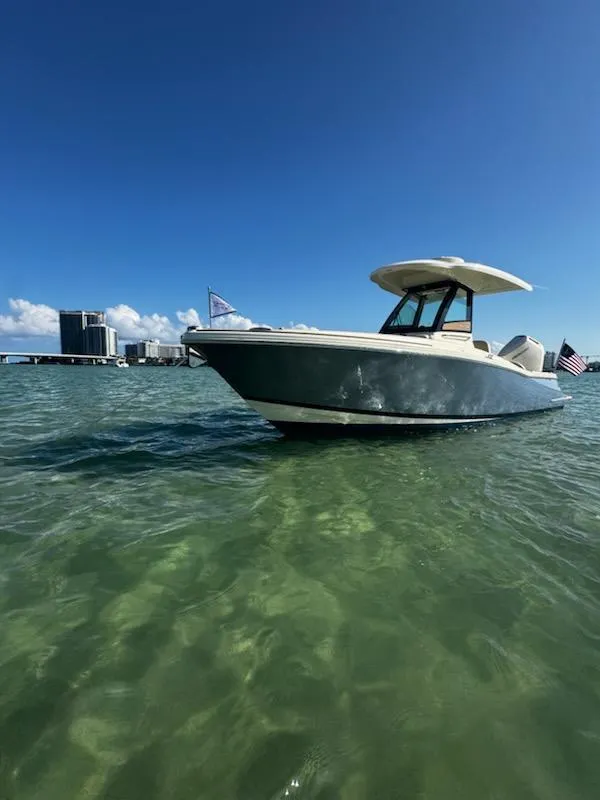 Slide: The Image of 2024 Chris-Craft Catalina 24 boat on clear water with city skyline in background. - 63