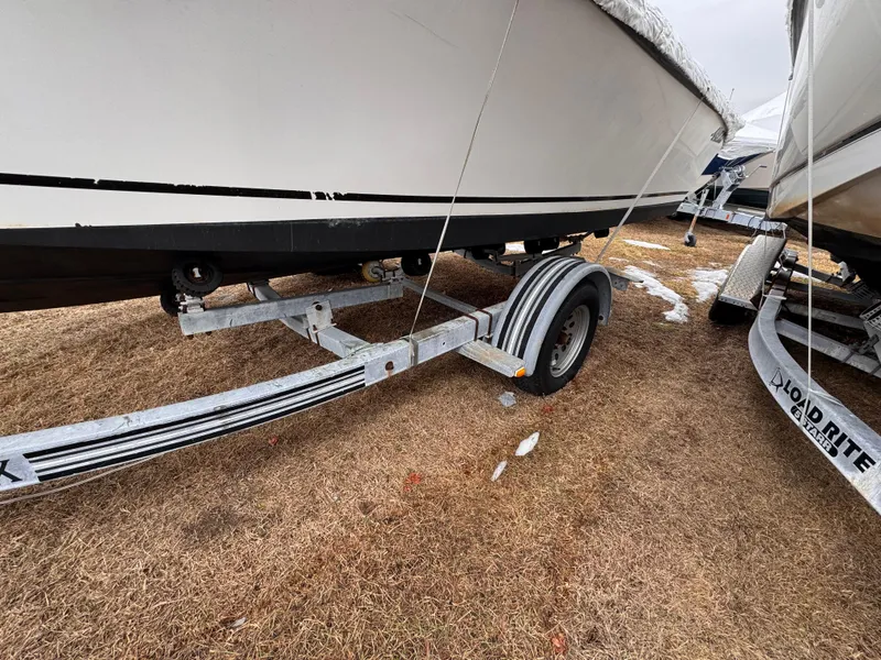 Slide: The Image of 1997 Mako 191 boat on a trailer, parked on dry grass. - 10