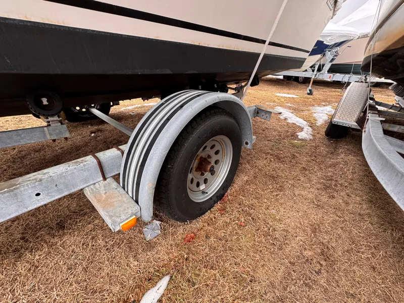 Slide: The Image of Trailer wheel of a 1997 Mako 191 boat on dry grass. - 11