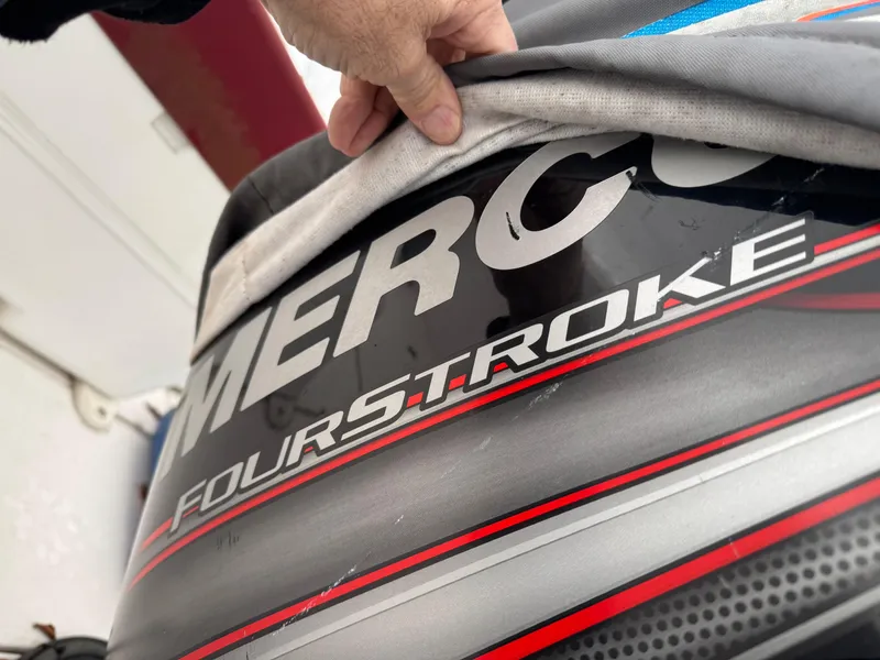 Slide: The Image of Hand revealing Mako 191 boat engine cover, featuring "Four Stroke" text, 1997 model. - 3