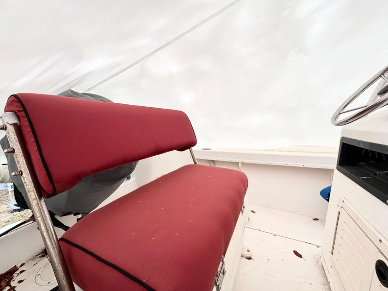 Slide: The Image of Red cushioned seat on 1997 Mako 191 boat interior, white background. - 6