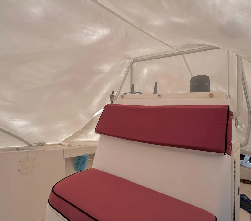 Slide: The Image of Interior of a 1997 Mako 191 boat with red cushioned seating. - 7