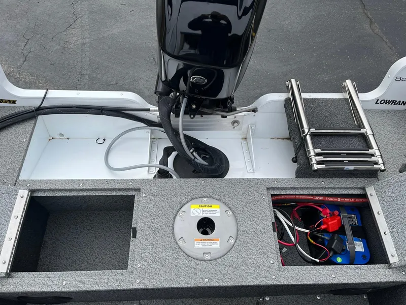 Slide: The Image of 2023 Lund 1650 Rebel XL SS boat interior with motor, storage compartments, and ladder. - 11