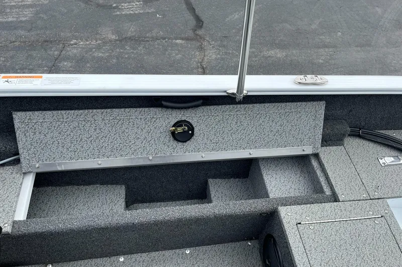 Slide: The Image of 2023 Lund 1650 Rebel XL SS boat interior with storage compartments and textured flooring. - 22