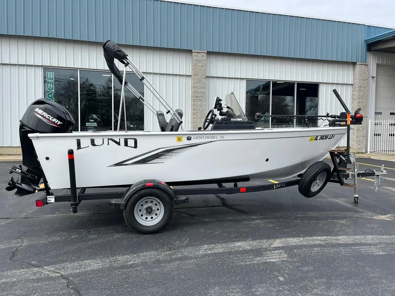 Slide: The Image of 2023 Lund 1650 Rebel XL SS boat on trailer, parked outside a building. - 3