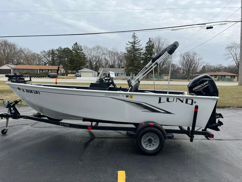 Slide: The Image of 2023 Lund 1650 Rebel XL SS boat on trailer, parked outdoors. - 4