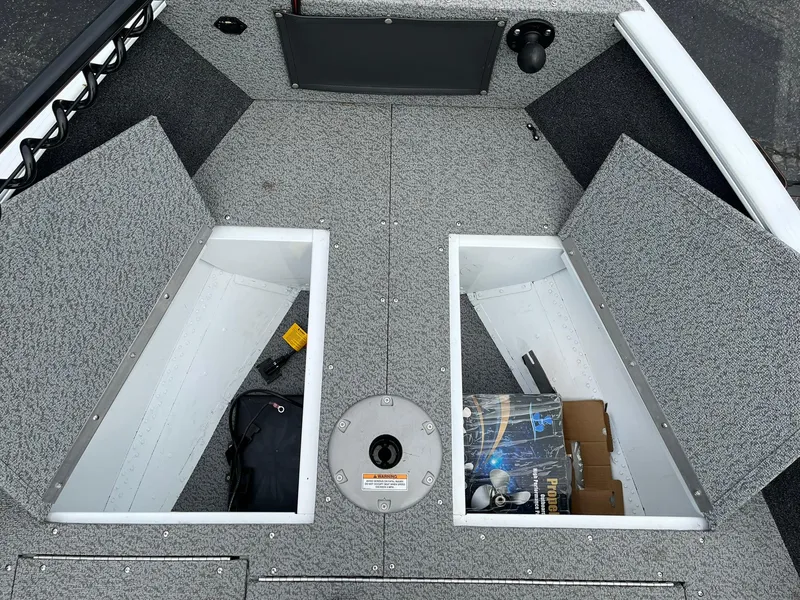 Slide: The Image of 2023 Lund 1650 Rebel XL SS boat storage compartments with open lids, showcasing interior space. - 8