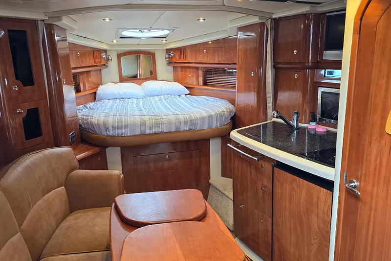 Slide: The Image of Luxurious 2007 Four Winns 358 Vista cabin interior with bed, kitchenette, and seating area. - 15