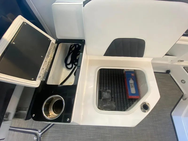 Slide: The Image of 2023 Monterey 298 SUPER SPORT BR boat interior with storage compartments and cup holder. - 19