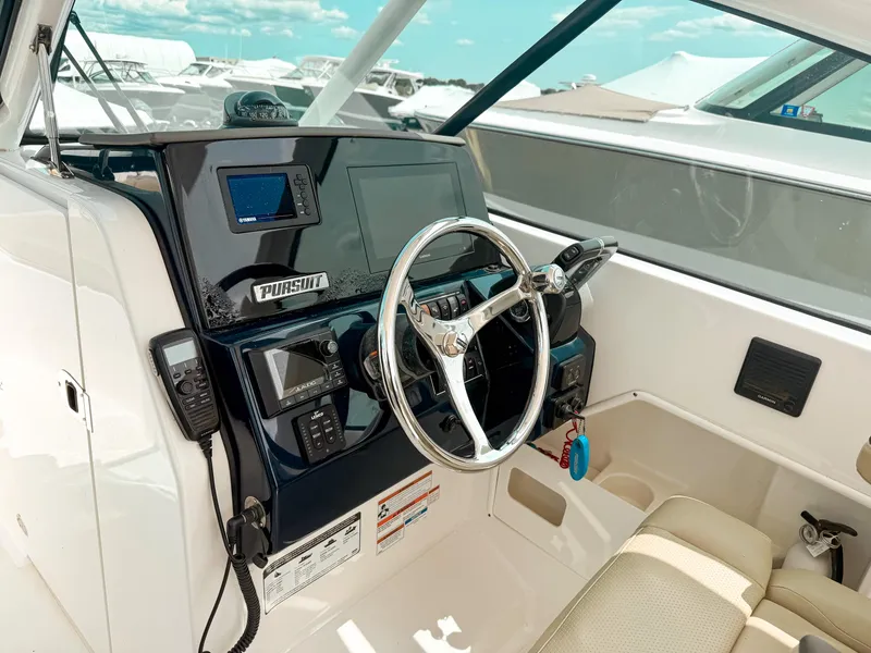 Slide: The Image of 2020 Pursuit DC 266 Dual Console boat cockpit with steering wheel and navigation controls. - 13