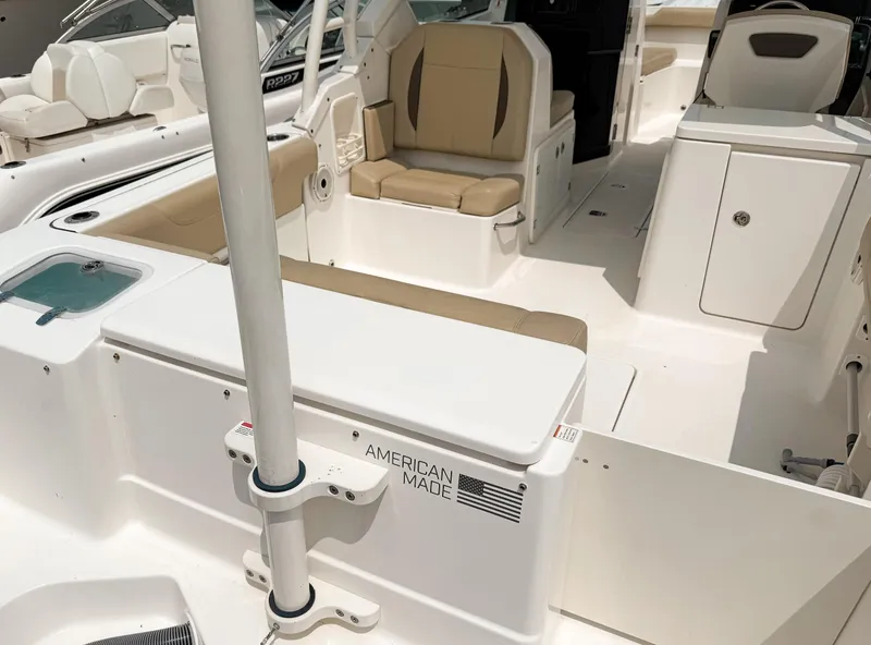 Slide: The Image of 2020 Pursuit DC 266 Dual Console boat interior with beige seating and storage compartments. - 22