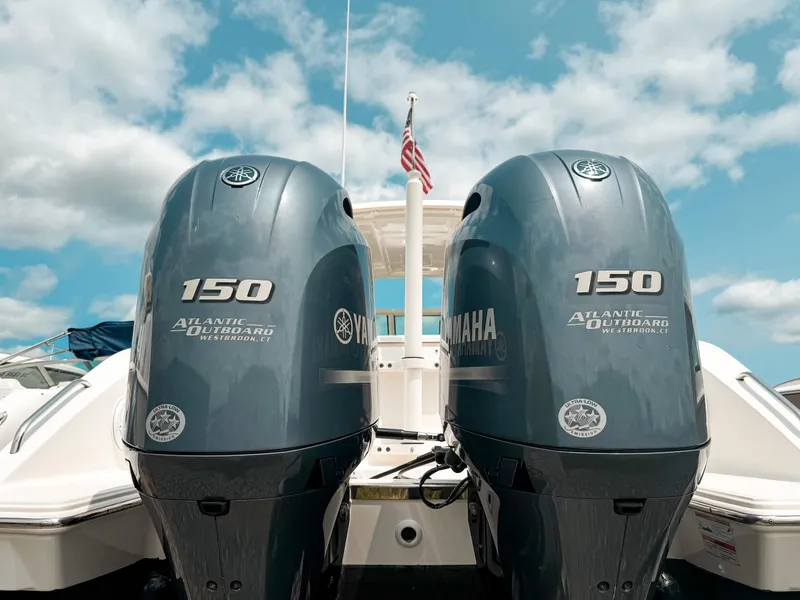 Slide: The Image of 2020 Pursuit DC 266 Dual Console with twin Yamaha 150 outboard engines under a blue sky. - 24