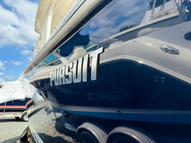 Slide: The Image of 2020 Pursuit DC 266 Dual Console boat with reflective blue hull. - 4