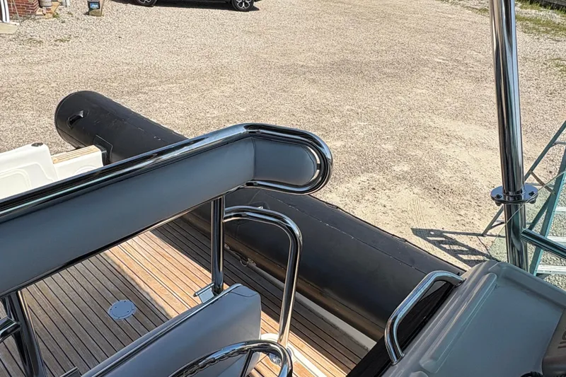 Slide: The Image of 2013 Protector 25 Center Console boat with sleek railing and wooden deck. - 10