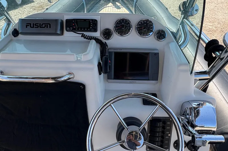 Slide: The Image of 2013 Protector 25 Center Console boat dashboard with steering wheel and navigation instruments. - 11