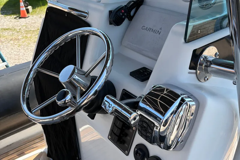 Slide: The Image of 2013 Protector 25 Center Console boat steering wheel and controls. - 12
