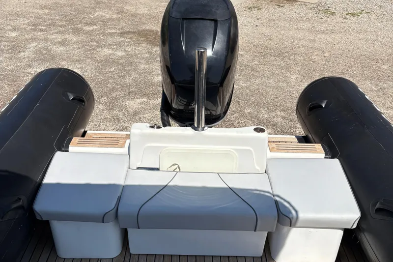 Slide: The Image of 2013 Protector 25 Center Console boat with outboard motor and seating area. - 14