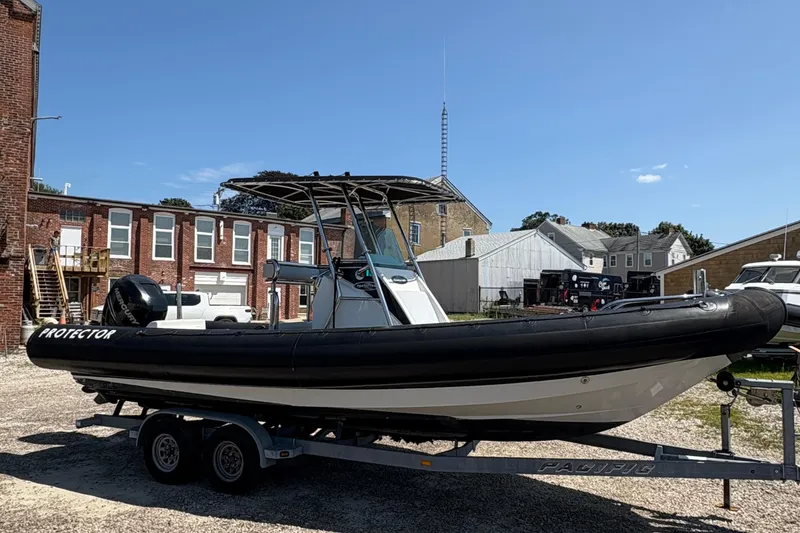 Slide: The Image of 2013 Protector 25 Center Console boat on trailer, parked outdoors. - 3
