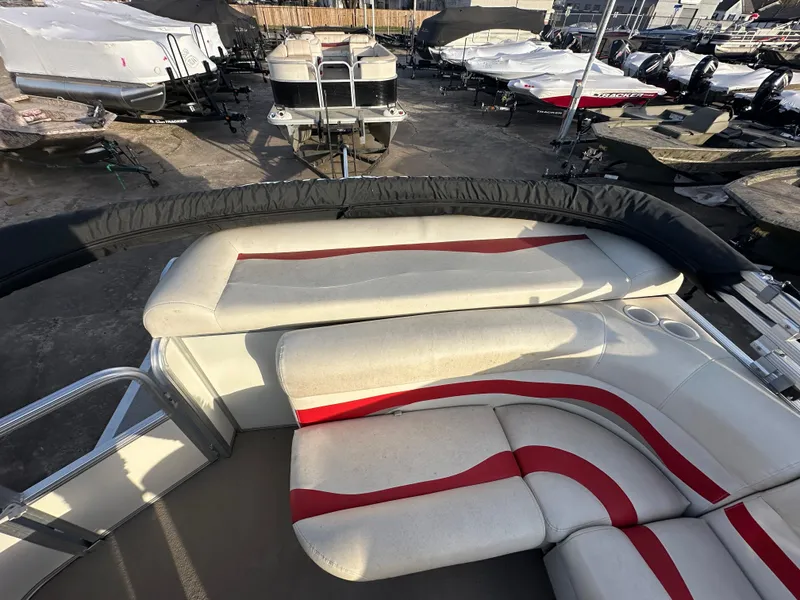 Slide: The Image of 2009 Sun Tracker PARTY BARGE 200 Classic Series with red and white seating in a boatyard. - 12