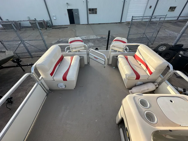 Slide: The Image of 2009 Sun Tracker PARTY BARGE 200 Classic Series with red and white seating, docked near a warehouse. - 13