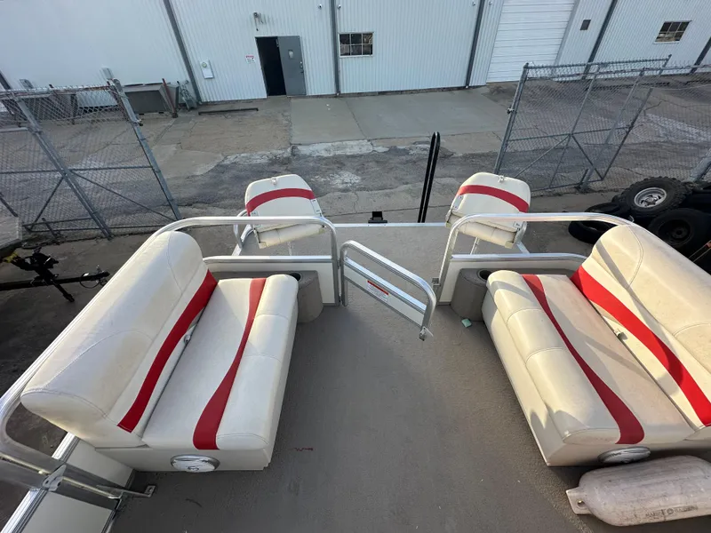 Slide: The Image of 2009 Sun Tracker PARTY BARGE 200 Classic Series with red and white seating, docked near a warehouse. - 14