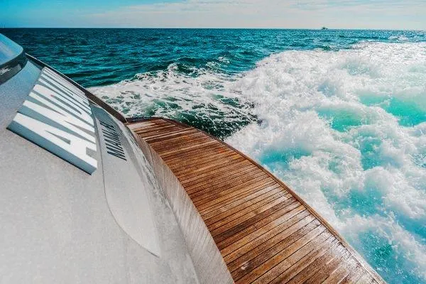 Slide: The Image of 2015 Pershing 70 yacht cruising on open sea with wooden deck and ocean waves. - 24