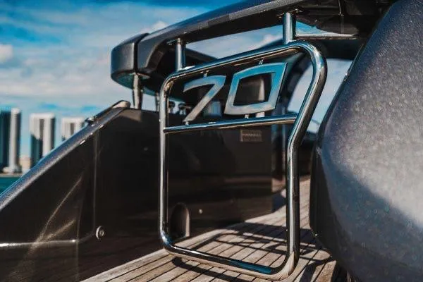 Slide: The Image of 2015 Pershing 70 yacht detail with chrome railing and city skyline background. - 25