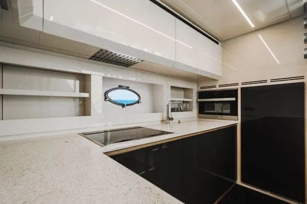 Slide: The Image of Modern kitchen interior on a 2015 Pershing 70 yacht, featuring sleek cabinetry and appliances. - 47