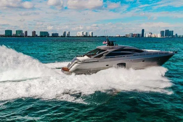 Slide: The Image of 2015 Pershing 70 yacht cruising on turquoise waters near a city skyline. - 5