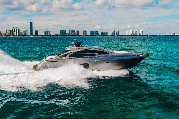 Slide: The Image of 2015 Pershing 70 yacht cruising on turquoise waters with city skyline in background. - 7