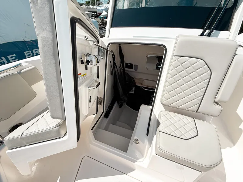 Slide: The Image of 2024 Pursuit S 288 Sport boat interior with open storage compartment and cushioned seating. - 17