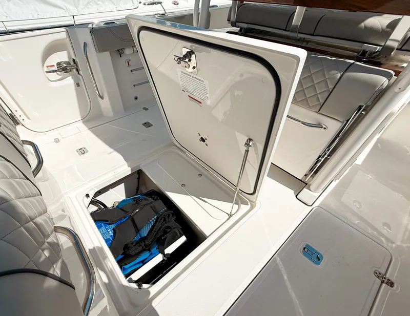 Slide: The Image of 2024 Pursuit S 288 Sport boat storage compartment with open hatch and visible equipment. - 20