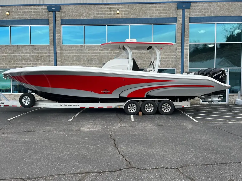 The Image of 2019 Fountain 39 NX boat on trailer, red and white design, parked outside building. - 1