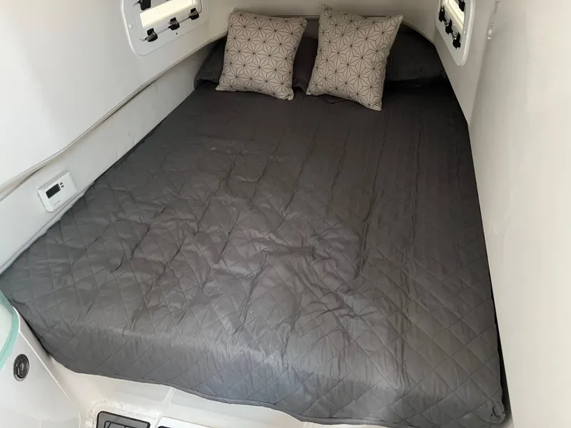 Slide: The Image of Cozy cabin bed in 2019 Fountain 39 NX boat with gray bedding and pillows. - 20