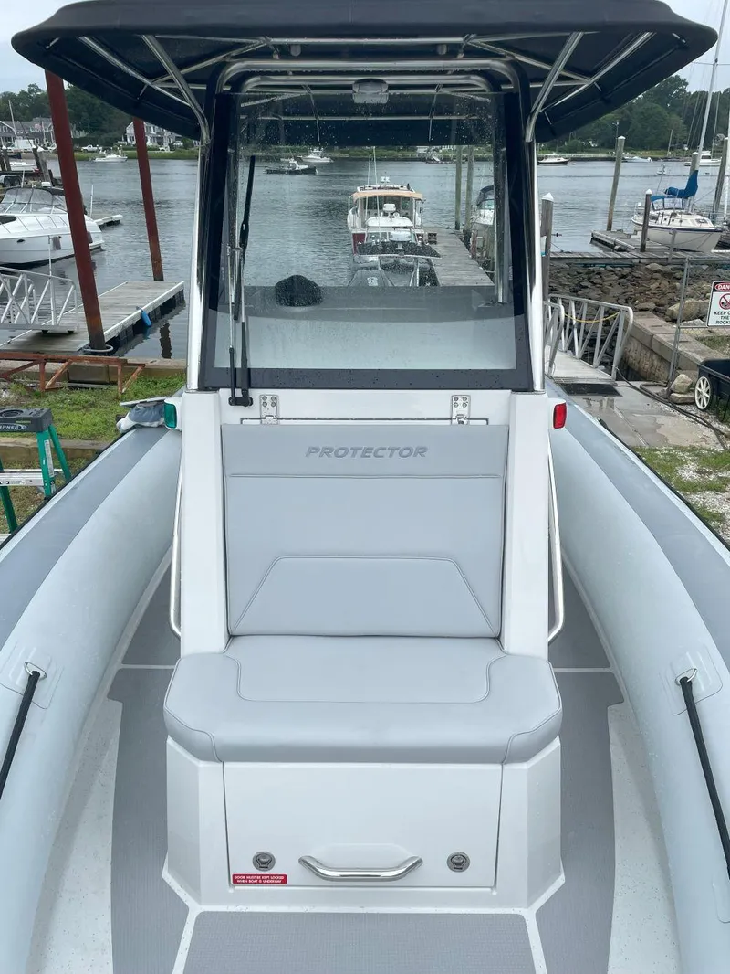 Slide: The Image of 2023 Protector 250 Chase boat docked at marina, featuring sleek design and spacious seating. - 11