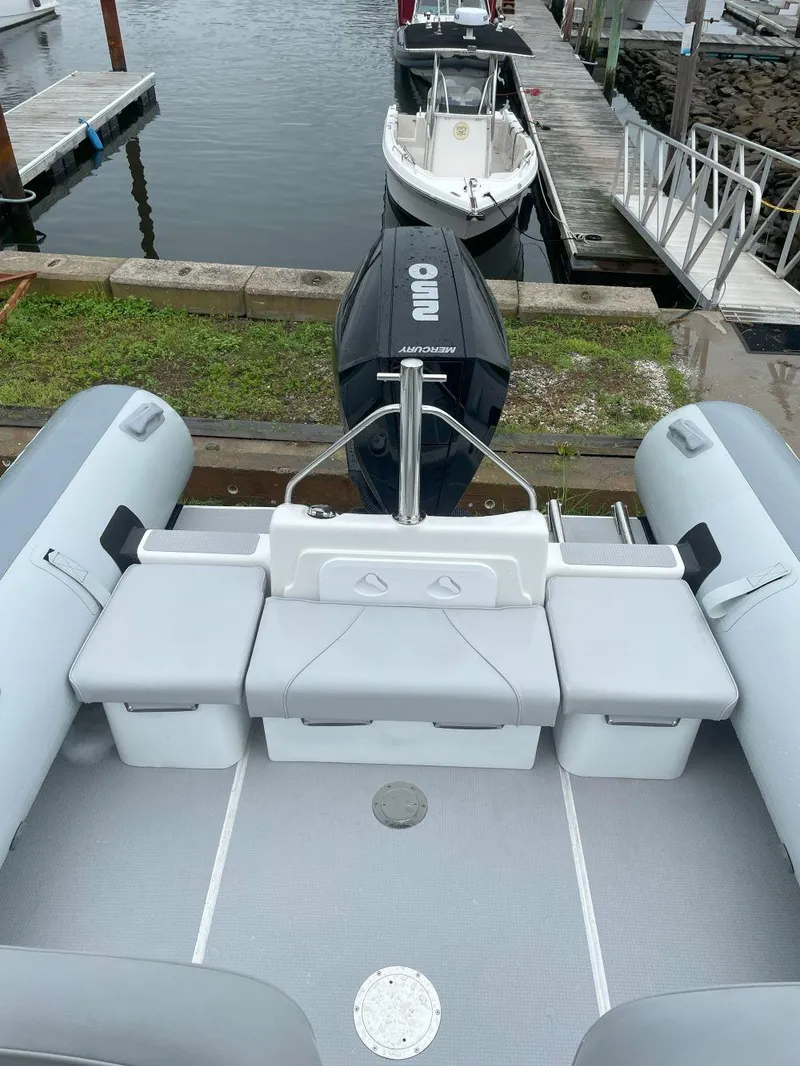 Slide: The Image of 2023 Protector 250 Chase boat docked, featuring spacious seating and modern design. - 12