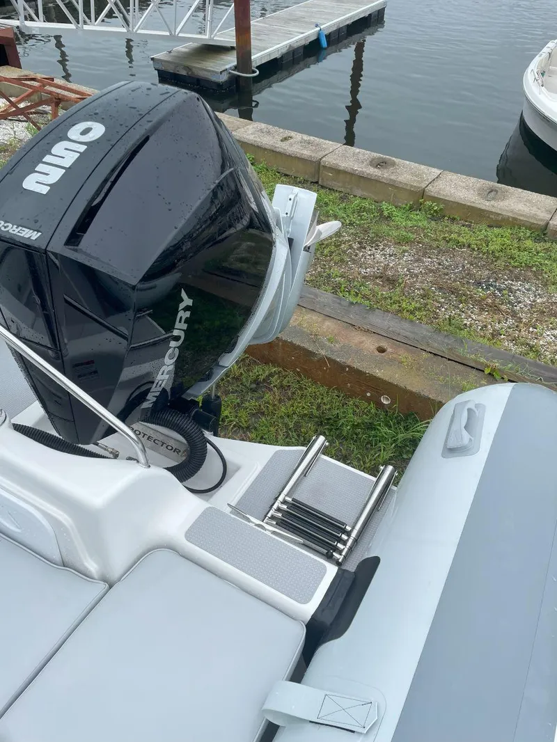 Slide: The Image of 2023 Protector 250 Chase boat with Mercury engine docked by the water. - 13