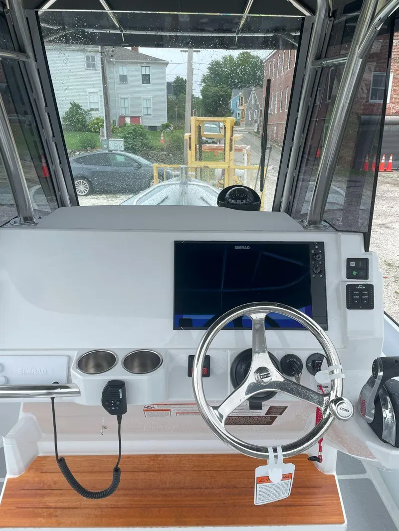 Slide: The Image of 2023 Protector 250 Chase boat dashboard with steering wheel and navigation screen. - 8