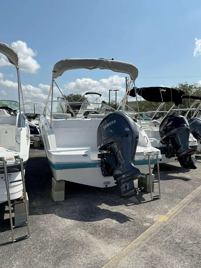 Slide: The Image of 2025 Hurricane 235 SD boat with Yamaha outboard motor, parked under a clear blue sky. - 3