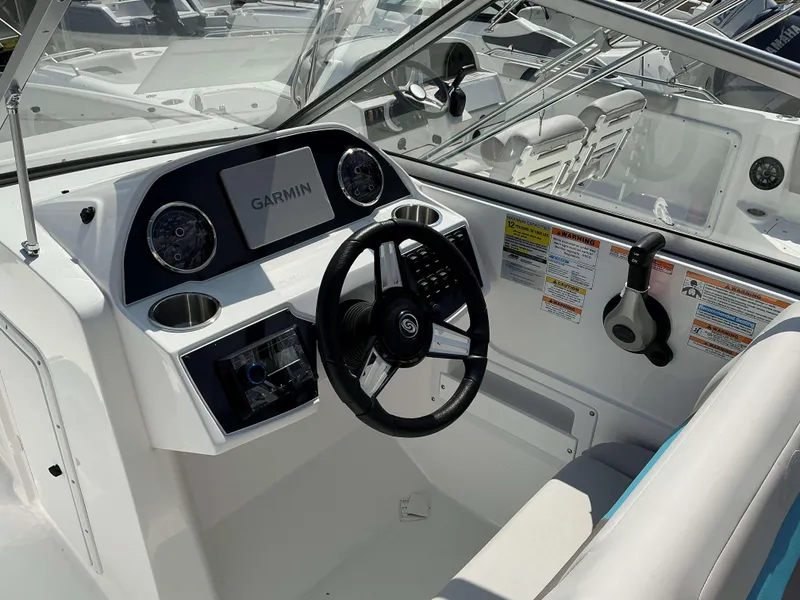 Slide: The Image of 2025 Hurricane 235 SD boat dashboard with Garmin display and steering wheel. - 4