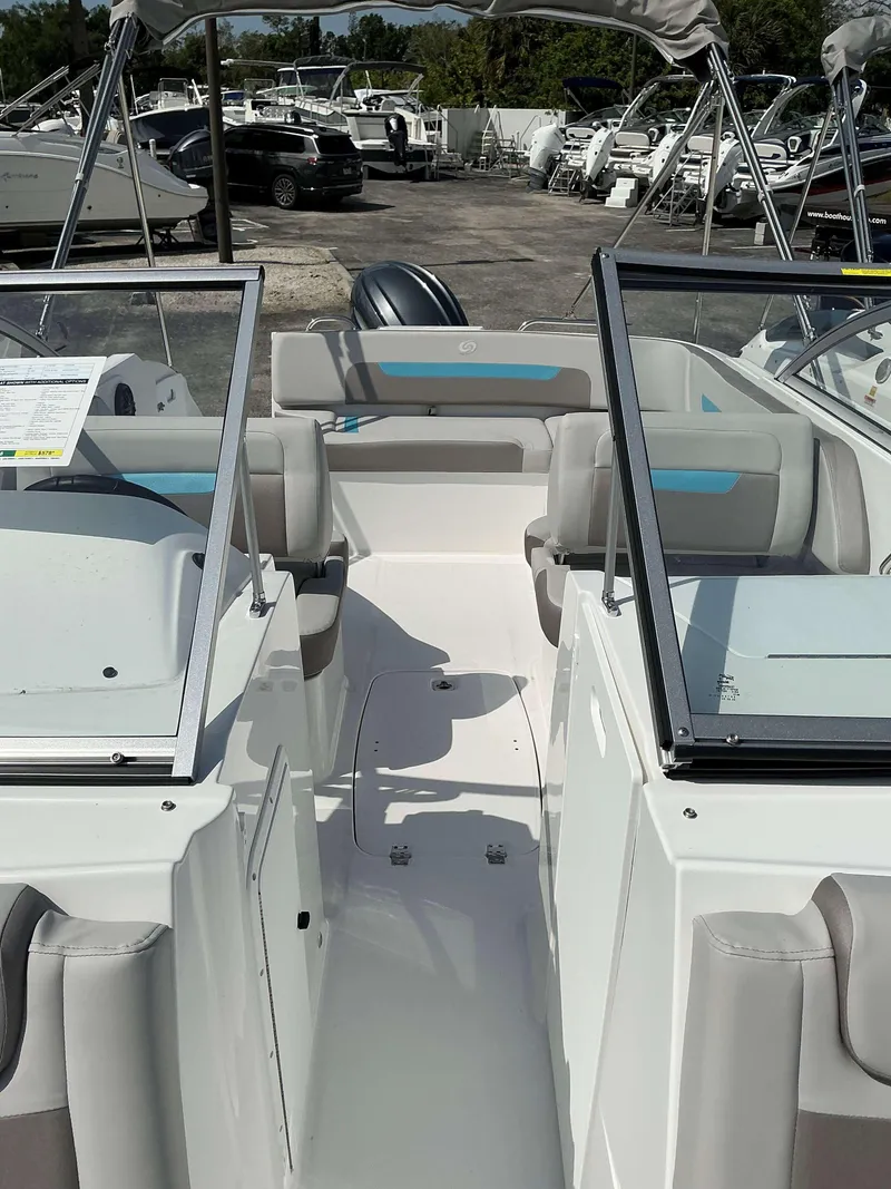 Slide: The Image of 2025 Hurricane 235 SD boat interior with seating and windshield, docked among other boats. - 6