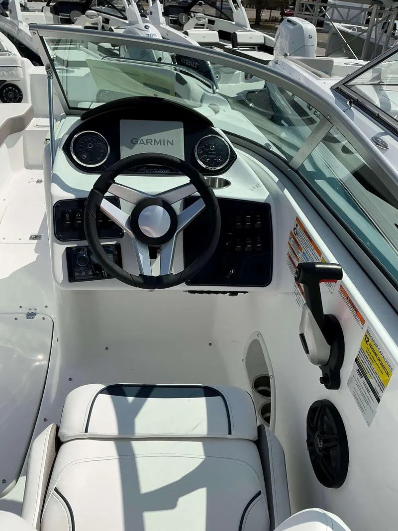 Slide: The Image of 2025 Hurricane 2400 SD boat cockpit with Garmin navigation system and modern steering wheel. - 13