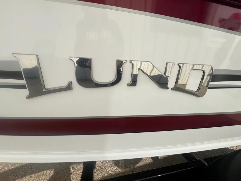 Slide: The Image of 2014 Lund 1875 Crossover XS boat logo on white and red exterior. - 2