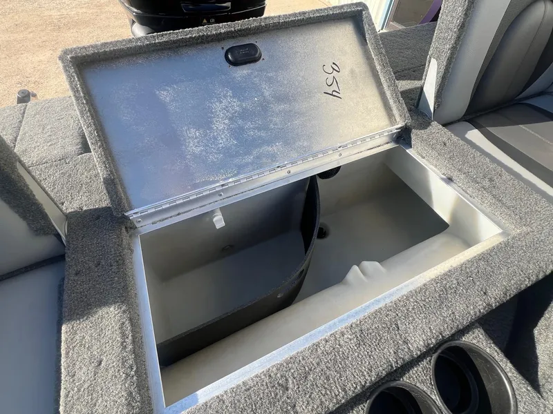 Slide: The Image of Open storage compartment in 2014 Lund 1875 Crossover XS boat, featuring carpeted interior. - 22