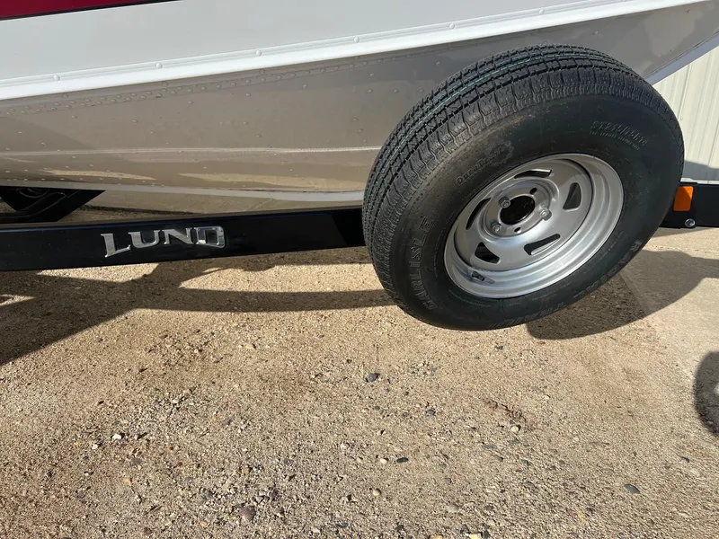 Slide: The Image of 2014 Lund 1875 Crossover XS trailer tire on sandy ground. - 25