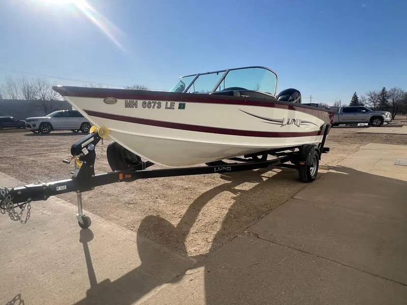 Slide: The Image of 2014 Lund 1875 Crossover XS boat on trailer, parked outdoors under clear sky. - 4