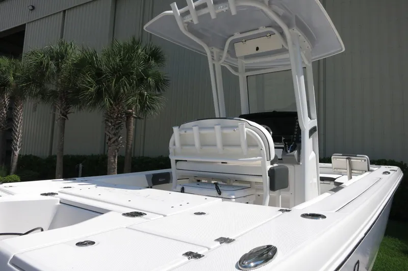 Slide: The Image of 2025 Robalo 246 Cayman boat with T-top, white deck, and seating, near palm trees. - 10