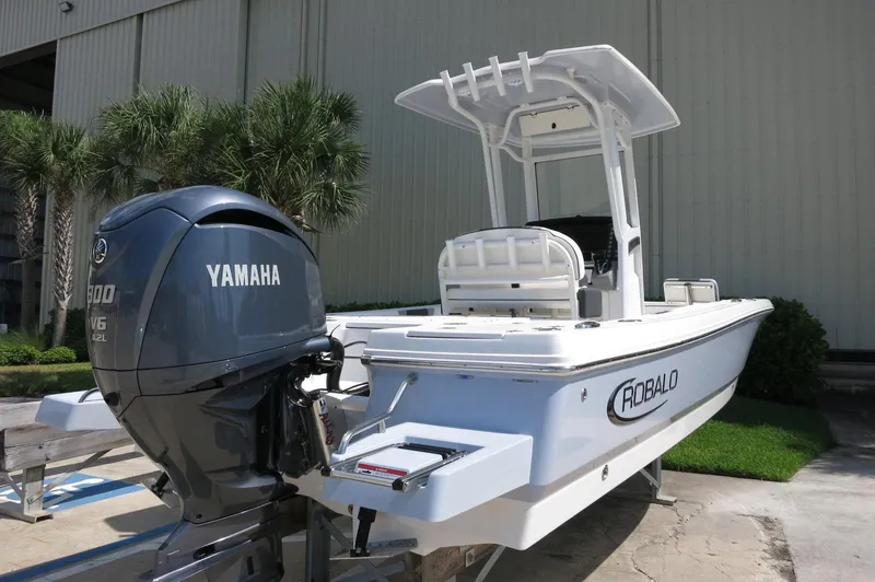 Slide: The Image of 2025 Robalo 246 Cayman boat with Yamaha engine, parked outdoors. - 5