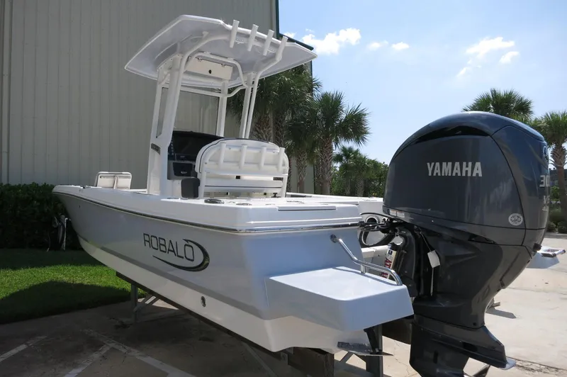 Slide: The Image of 2025 Robalo 246 Cayman boat with Yamaha engine, parked outdoors near palm trees. - 7