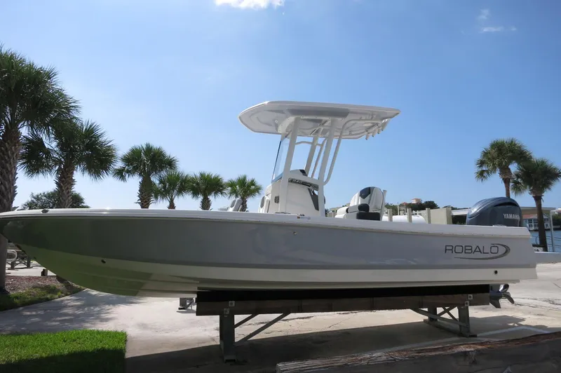 Slide: The Image of 2025 Robalo 246 Cayman boat on display, surrounded by palm trees and clear skies. - 8